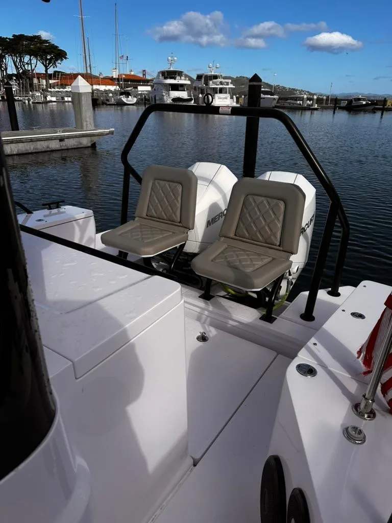 Slide: The Image of 2022 Axopar 28 CABIN boat with twin Mercury engines docked at a marina. - 28