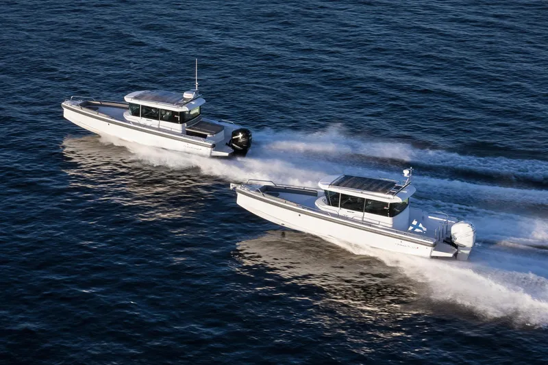 Slide: The Image of Two 2022 Axopar 28 CABIN boats speeding on open water. - 4