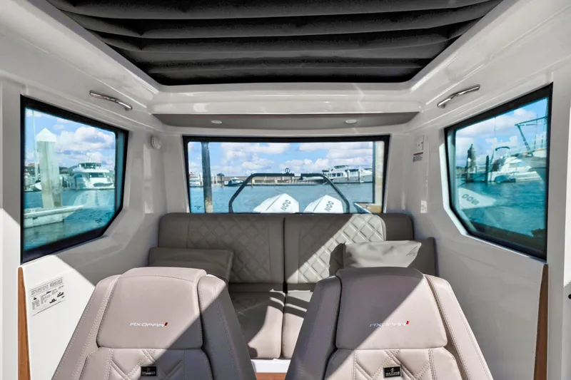 Slide: The Image of Interior of 2022 Axopar 28 CABIN boat with panoramic windows and plush seating. - 5