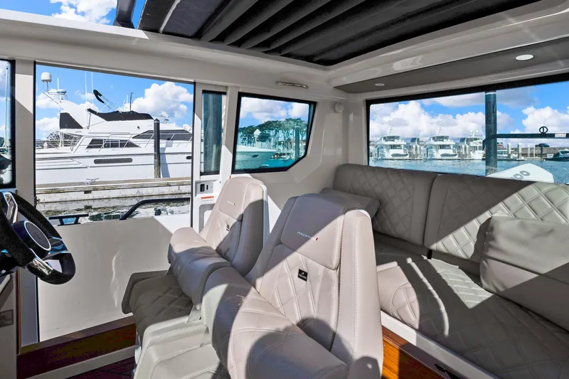 Slide: The Image of Interior of 2022 Axopar 28 CABIN boat with luxurious seating and marina view. - 6