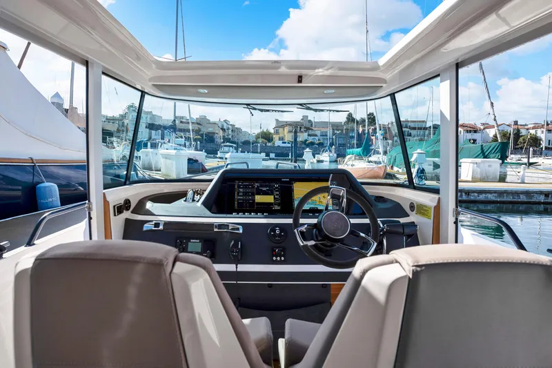 Slide: The Image of Interior view of 2022 Axopar 28 CABIN boat with modern dashboard and steering wheel. - 7