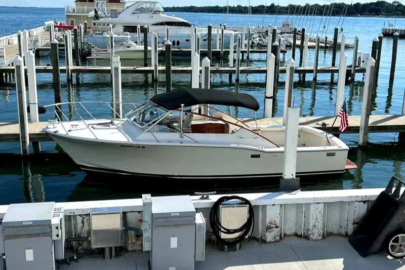 Slide: The Image of 1977 Chris-Craft 30 Sportsman boat docked at a marina with clear blue water. - 3