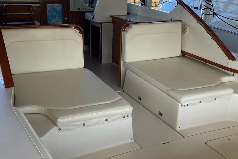 Slide: The Image of 1977 Chris-Craft 30 Sportsman interior with white cushioned seating and wooden accents. - 8