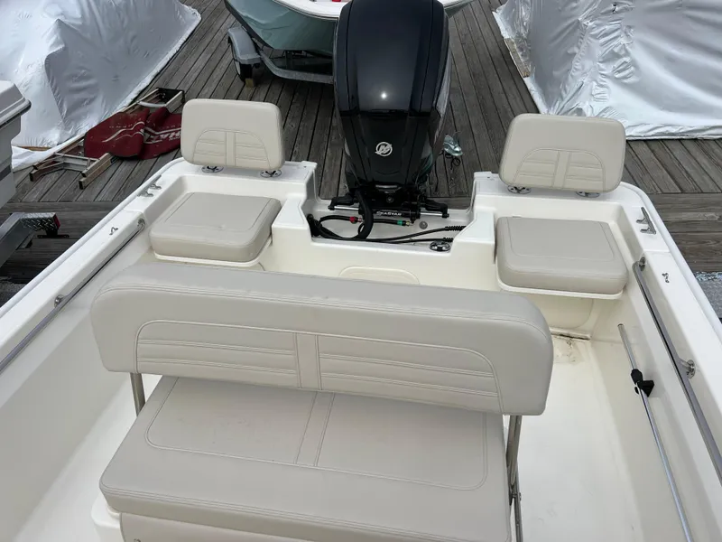 Slide: The Image of 2024 Boston Whaler 170 Montauk boat interior with seating and outboard motor. - 3