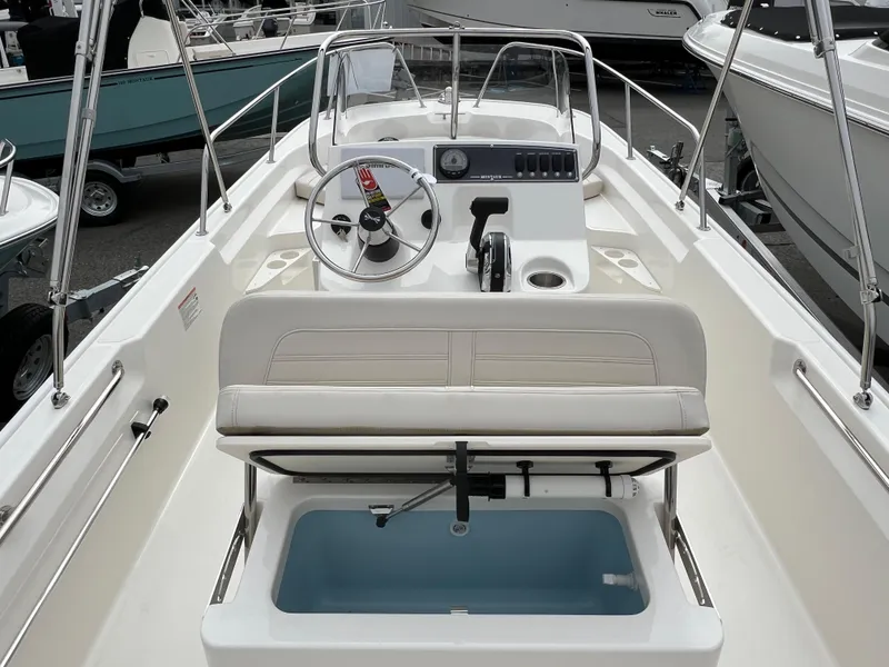Slide: The Image of 2024 Boston Whaler 170 Montauk boat interior with steering wheel and seating. - 4