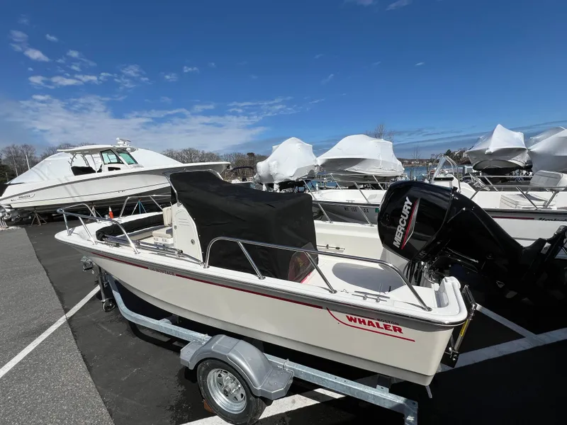 Slide: The Image of 2024 Boston Whaler 150 Montauk boat on trailer in marina. - 2