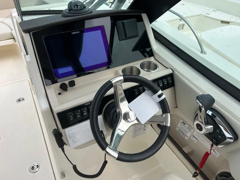 Slide: The Image of 2024 Boston Whaler 240 Vantage helm with steering wheel and navigation controls. - 4