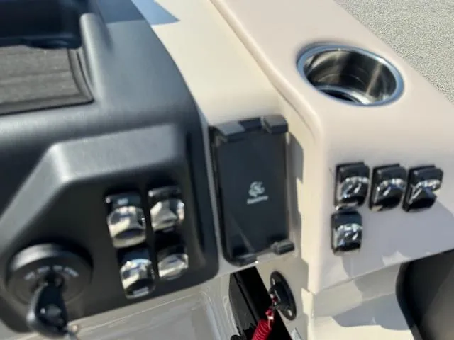 Slide: The Image of Control panel of 2024 Harris FloteBote Sunliner 230 pontoon boat with switches and cup holder. - 9