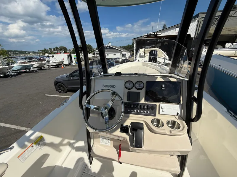 Slide: The Image of 2024 Boston Whaler 250 Dauntless boat console with steering wheel and navigation controls. - 2