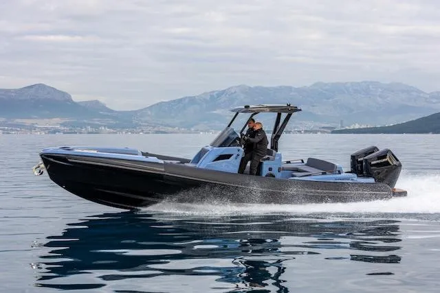 The Image of 2025 SuperRib Open 30 speedboat cruising on calm water with mountainous backdrop. - 0