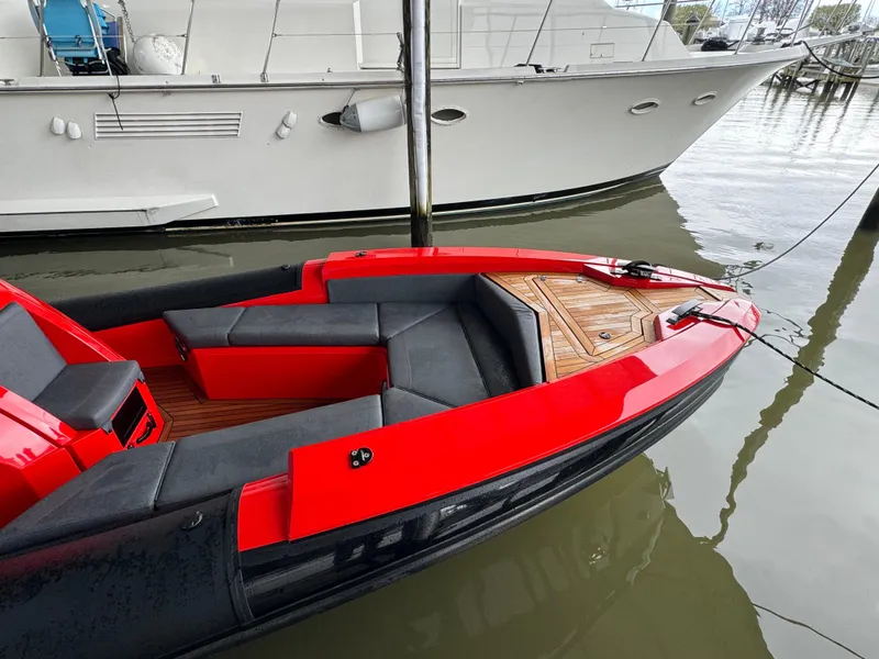 Slide: The Image of 2024 SuperRib Open 30 boat with red and black design docked in marina. - 12