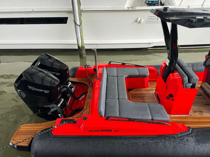 Slide: The Image of 2024 SuperRib Open 30 boat with twin outboard engines docked. - 15