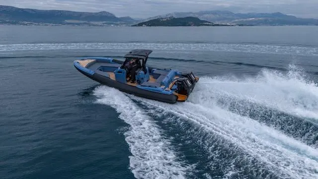 Slide: The Image of 2025 SuperRib Open 30 speedboat cruising on open water with scenic island backdrop. - 34
