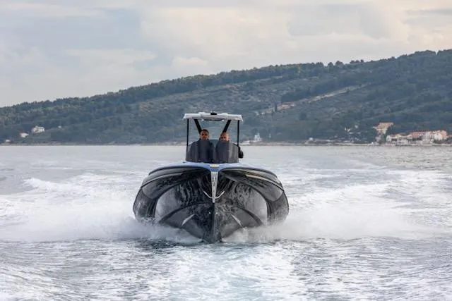 Slide: The Image of 2025 SuperRib Open 30 boat cruising on water with scenic background. - 46