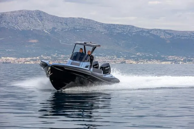 Slide: The Image of 2025 SuperRib Open 30 speedboat cruising on water with mountainous backdrop. - 48