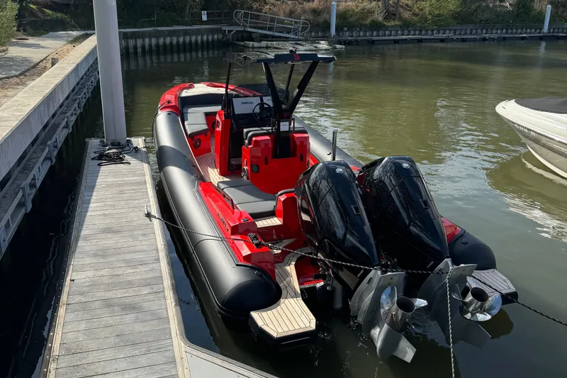 Slide: The Image of 2024 SuperRib Open 30 boat with twin engines docked at a marina. - 6