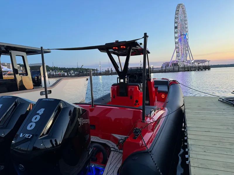 Slide: The Image of 2024 SuperRib Open 30 boat docked with Ferris wheel in background at sunset. - 8