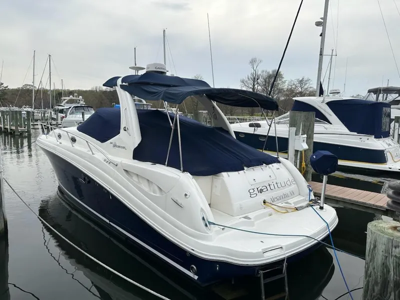 Slide: The Image of 2005 Sea Ray 340 Sundancer docked at a marina with blue canvas covers. - 5
