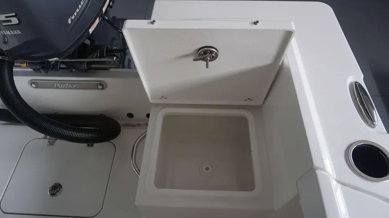 Slide: The Image of Open storage compartment on a 2024 Parker 18 SE CC boat with Yamaha outboard motor. - 14