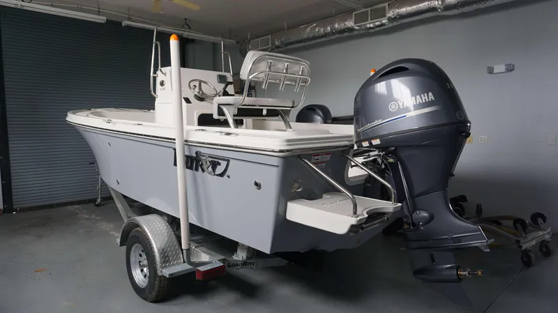 Slide: The Image of 2024 Parker 18 SE CC boat with Yamaha outboard motor in a garage. - 16