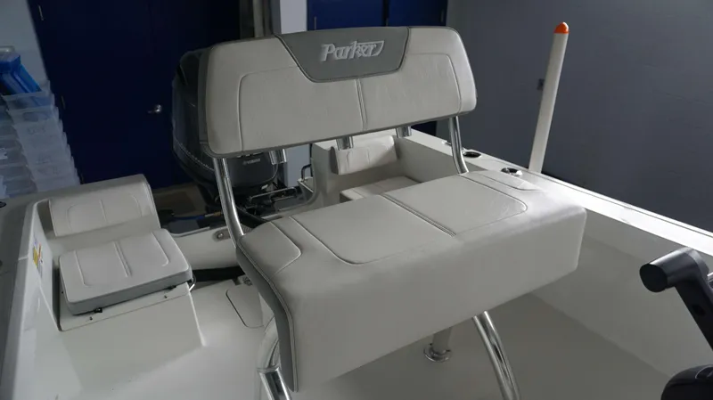 Slide: The Image of 2024 Parker 18 SE CC boat with cushioned seating and Yamaha outboard motor. - 18