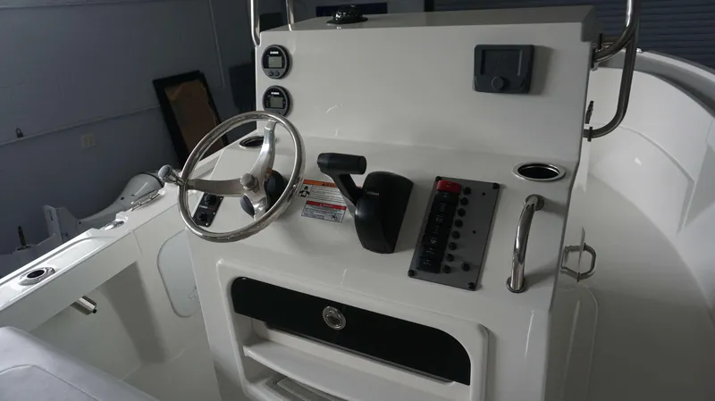 Slide: The Image of 2024 Parker 18 SE CC boat console with steering wheel, controls, and gauges. - 21