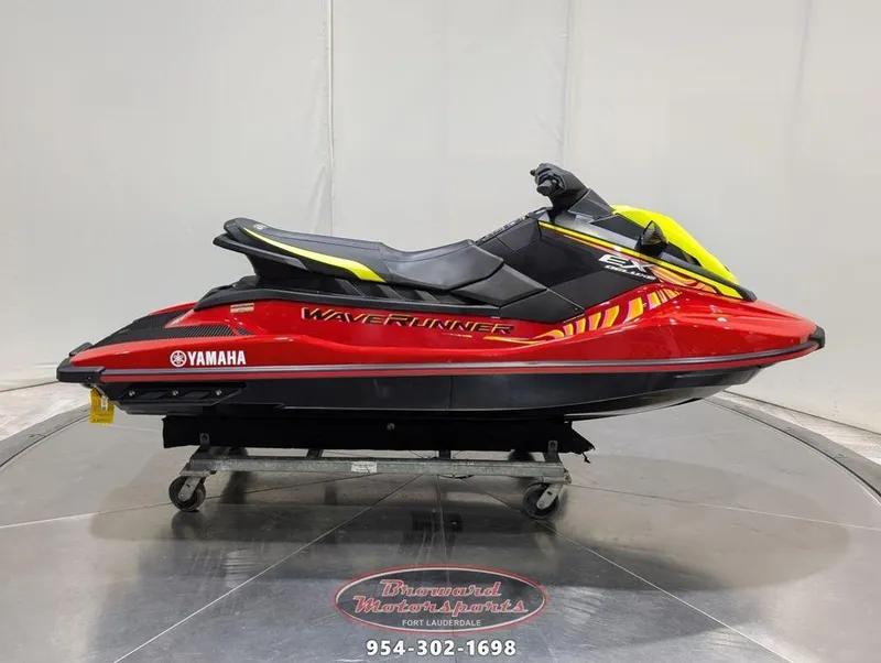 Slide: The Image of 2024 Yamaha EX® Deluxe WaveRunner in red and yellow on display stand. - 0