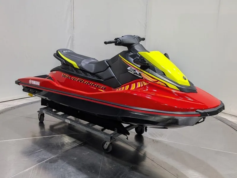 Slide: The Image of 2024 Yamaha EX® Deluxe WaveRunner, red and yellow, displayed indoors on a stand. - 28