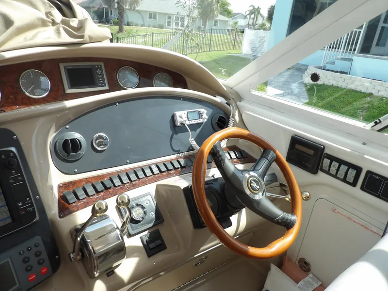 Slide: The Image of 2003 Sea Ray 390 Motor Yacht helm with wooden steering wheel and control panel. - 34