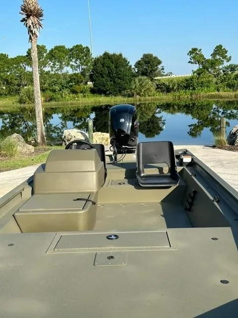 Slide: The Image of 2024 Tracker Grizzly 1754 SC boat on a serene lake background. - 5