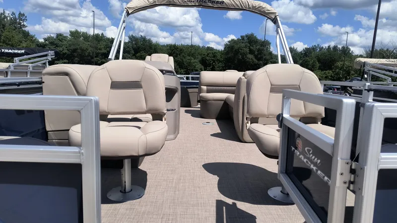 Slide: The Image of 2024 Sun Tracker Fishin' Barge 20 DLX pontoon boat with beige seating and open deck. - 3
