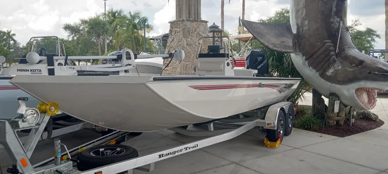 Slide: The Image of 2024 Ranger RB210 boat on trailer beside large shark sculpture. - 2