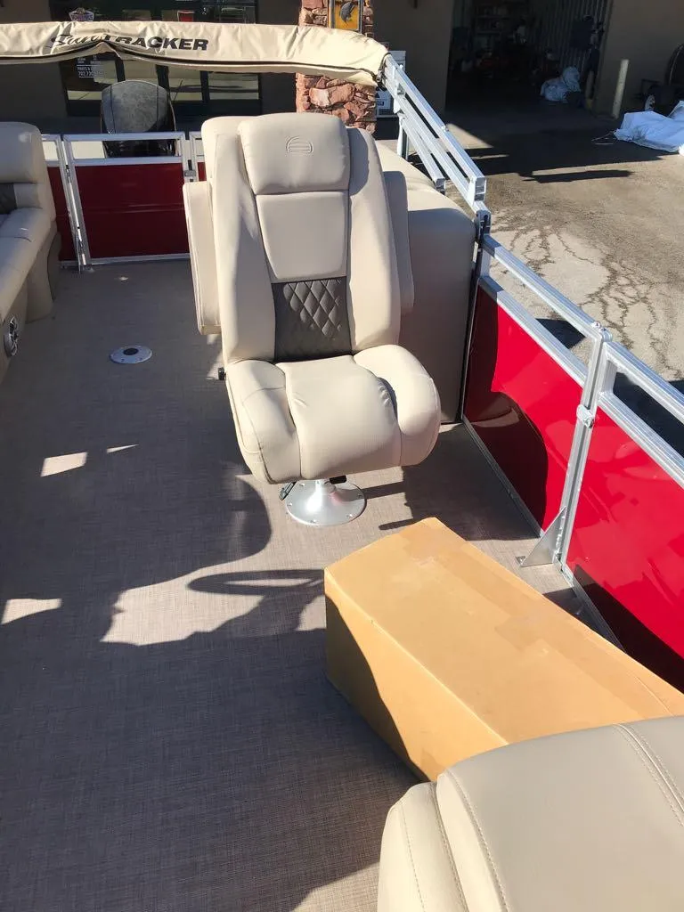 Slide: The Image of 2024 Sun Tracker Party Barge 24 DLX interior with beige seating and red accents. - 12