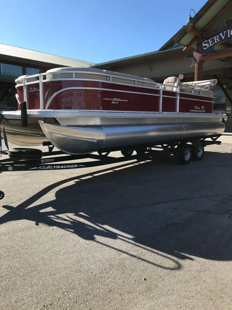 Slide: The Image of 2024 Sun Tracker Party Barge 24 DLX pontoon boat on trailer, parked outdoors. - 3