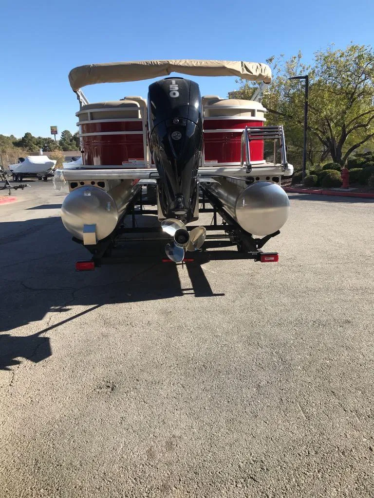 Slide: The Image of 2024 Sun Tracker Party Barge 24 DLX pontoon boat, rear view, parked outdoors. - 6