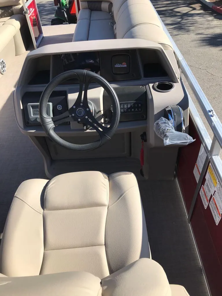 Slide: The Image of 2024 Sun Tracker Party Barge 24 DLX interior with steering wheel and seating. - 9