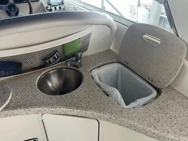 Slide: The Image of Rinker 310 Fiesta Vee 2000 boat interior with sink and trash bin. - 14