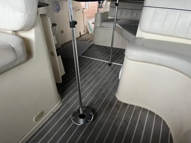 Slide: The Image of Interior of a 2000 Rinker 310 Fiesta Vee boat with white seating and grey flooring. - 15