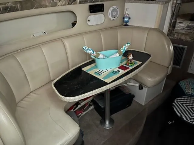 Slide: The Image of Interior of 2000 Rinker 310 Fiesta Vee with beige seating and a black table. - 18