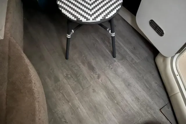 Slide: The Image of Interior of 2000 Rinker 310 Fiesta Vee with wood flooring and patterned stool. - 21