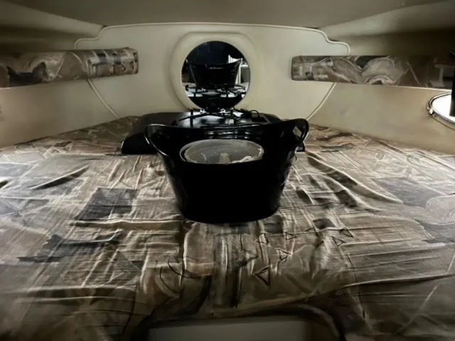 Slide: The Image of Interior cabin of a 2000 Rinker 310 Fiesta Vee boat with a bed and storage. - 22