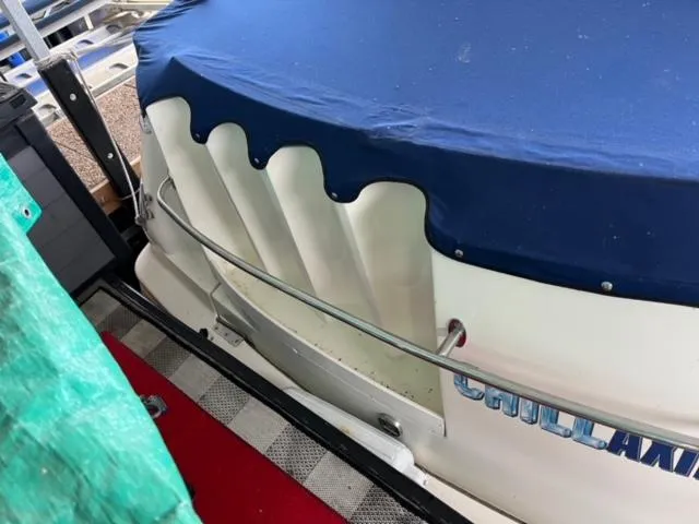 Slide: The Image of 2000 Rinker 310 Fiesta Vee boat with blue cover and rear railing. - 4