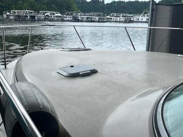 Slide: The Image of 2000 Rinker 310 Fiesta Vee boat docked at a marina with houseboats in the background. - 6