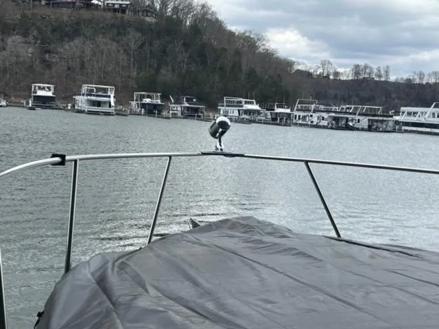 Slide: The Image of 2000 Rinker 310 Fiesta Vee boat docked on a calm lake with overcast skies. - 7