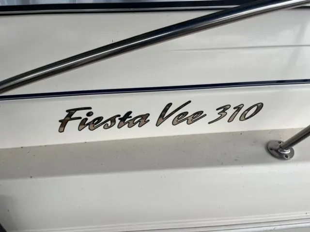 Slide: The Image of Rinker 310 Fiesta Vee 2000 boat model nameplate with stainless steel railing. - 8