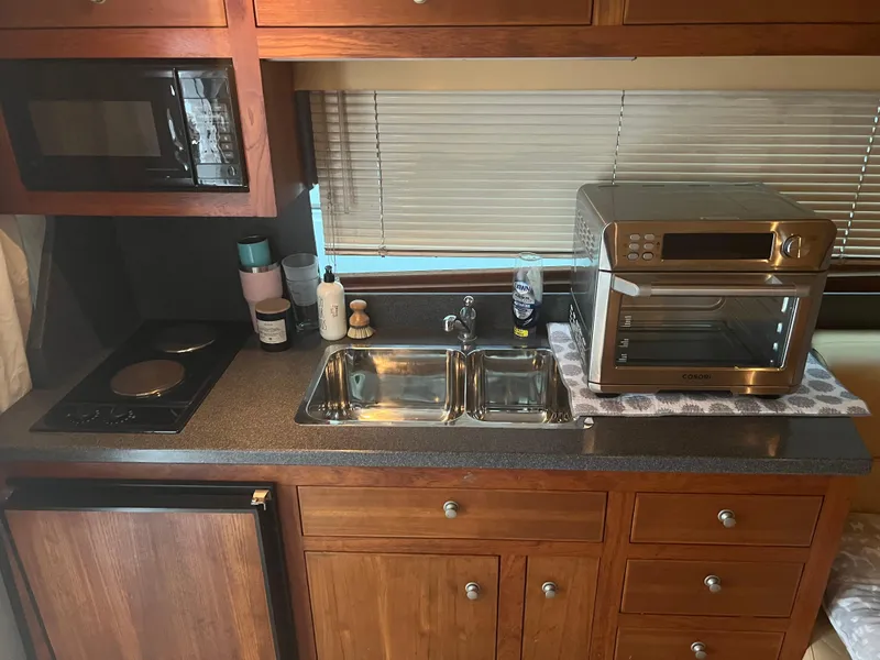 Slide: The Image of 2001 Luhrs 34 Convertible kitchen with microwave, sink, and toaster oven. - 18