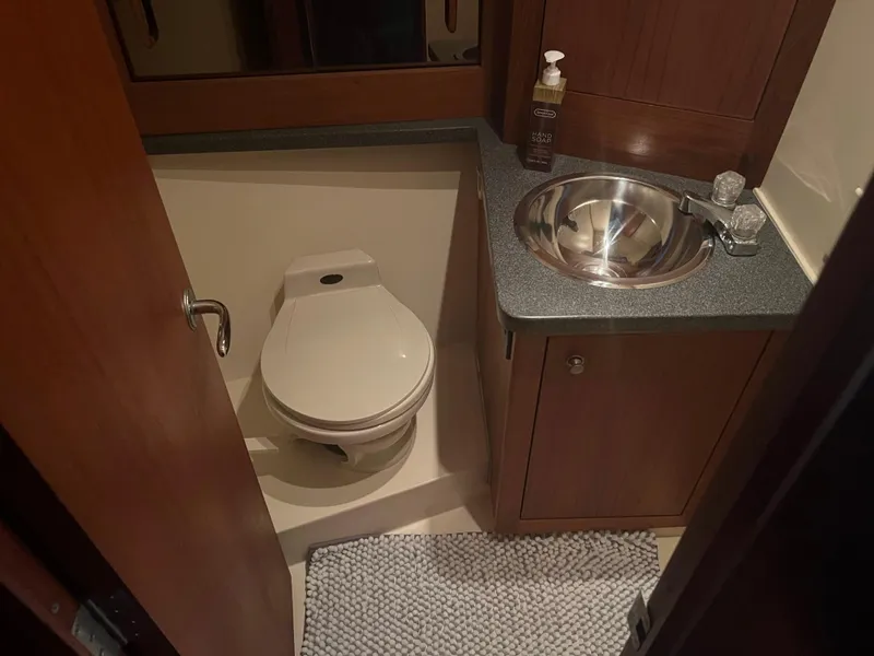 Slide: The Image of 2001 Luhrs 34 Convertible bathroom with toilet, sink, and countertop. - 21