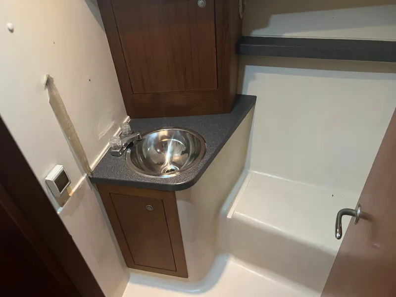 Slide: The Image of 2001 Luhrs 34 Convertible bathroom with sink and wooden cabinets. - 22