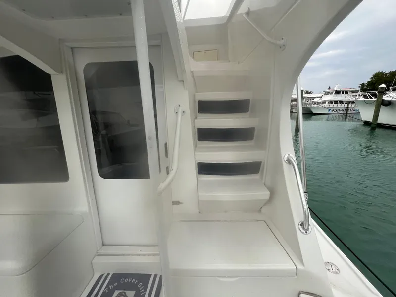 Slide: The Image of 2001 Luhrs 34 Convertible boat interior with stairs and marina view. - 8