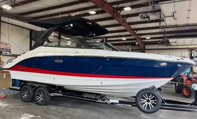 Slide: The Image of 2024 Sea Ray SLX 260 boat on trailer in indoor storage facility. - 1